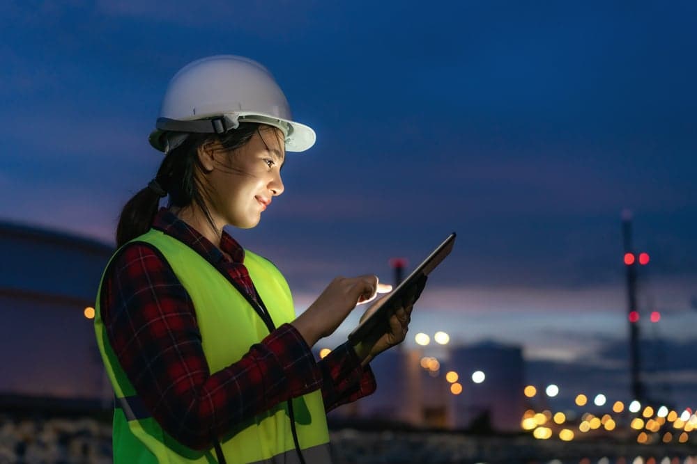 Asian,Woman,Petrochemical,Engineer,Working,At,Night,With,Digital,Tablet